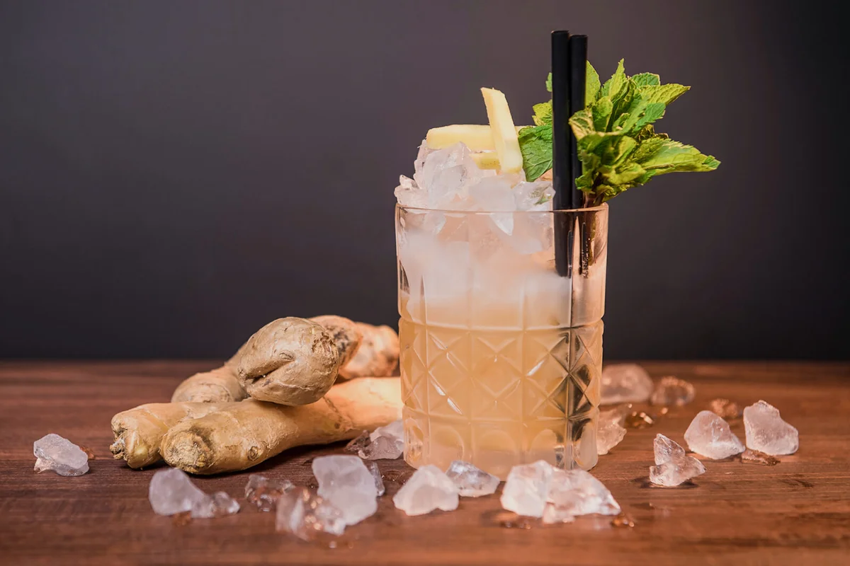Cocktail Glass And Ginger On Table Against Wall
