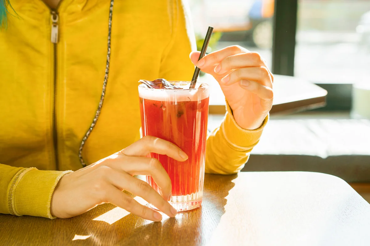 Woman with cocktail of summer cooling drink of lemonade in a glass
