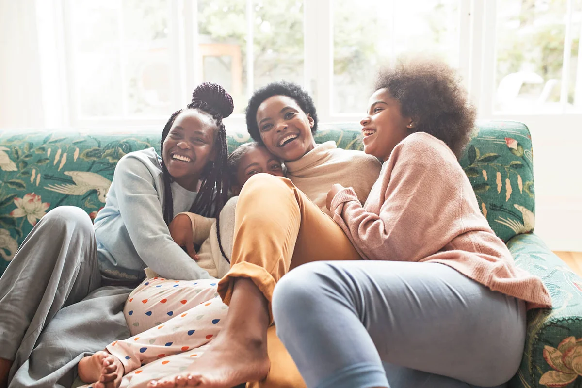 happy woman embracing girls at home