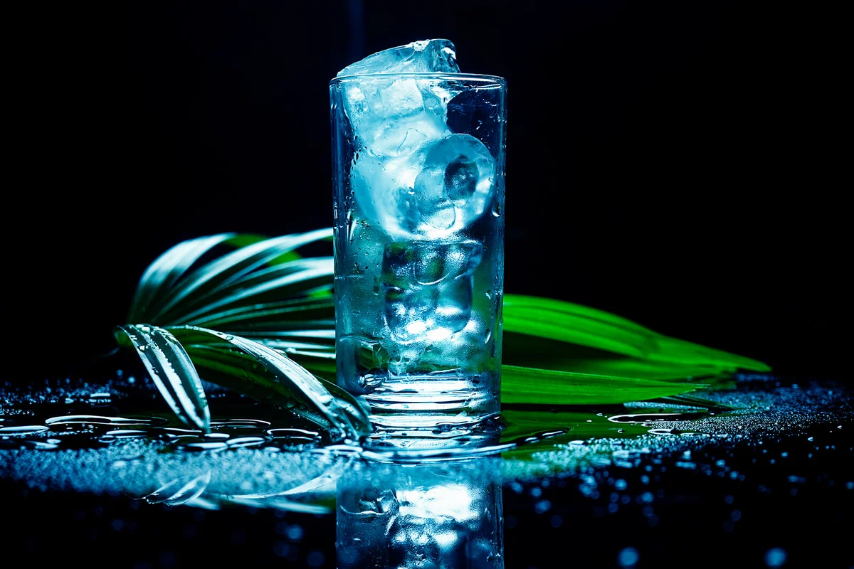 selective focus drink alcohol and water glass with whisky and Sparking water and ice cube