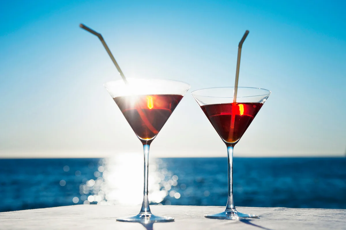Martinis with straws on table outdoors