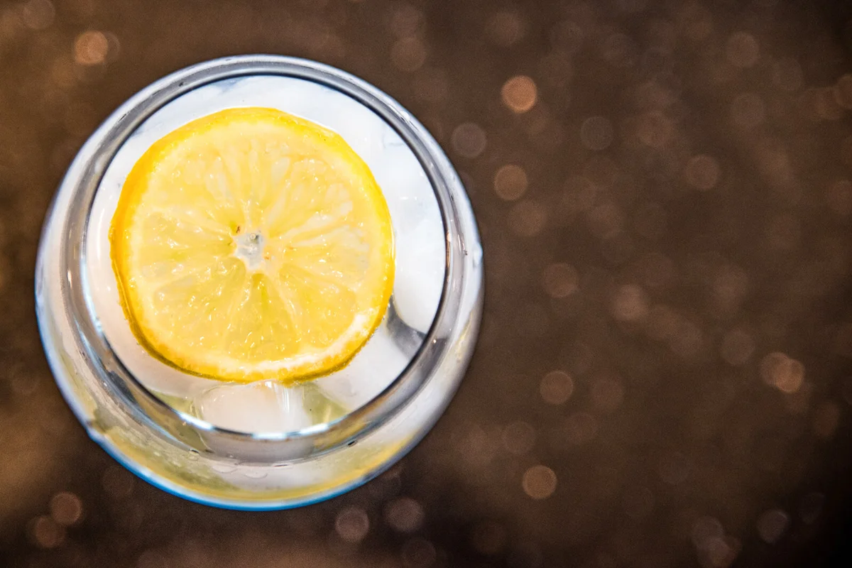 Overhead view of refreshing gin and tonic with ice and lemon