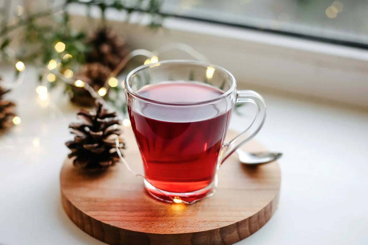 Hot homemade winter drink in glass cup on window sil