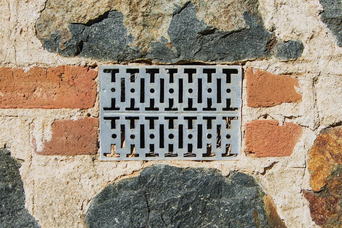 Stone exterior wall, with a metal air vent