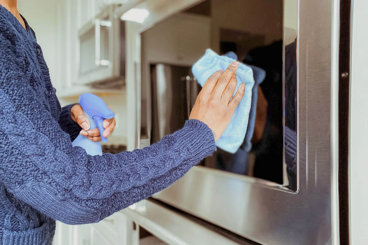 woman cleaning wall oven