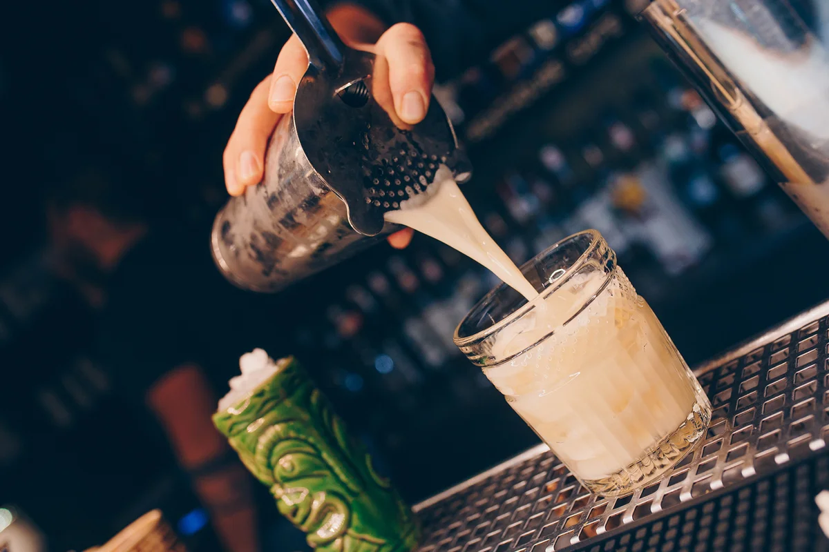 Bartender pouring using strainer
