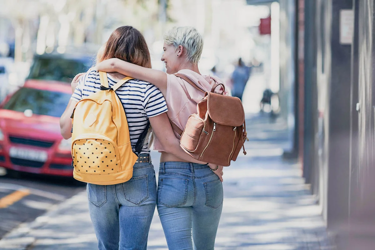 Two young women walking arm in arm
