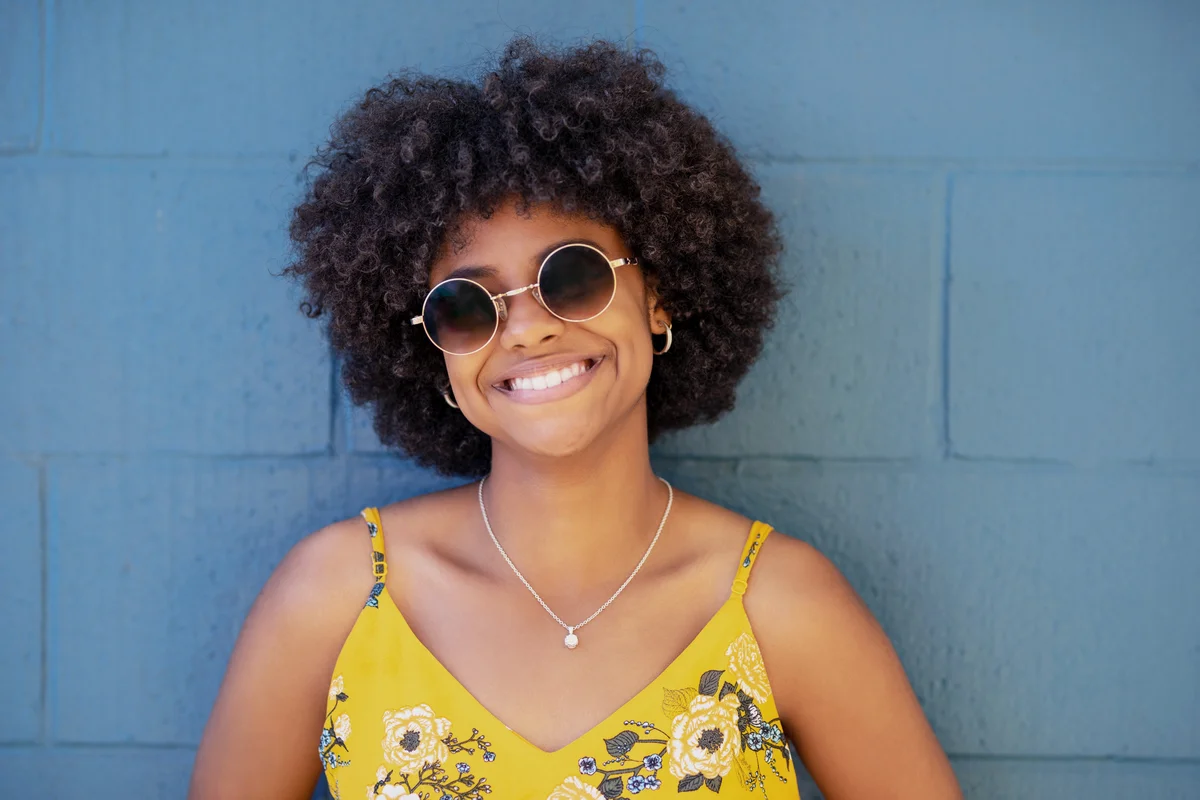 Beautiful young woman standing against blue wall