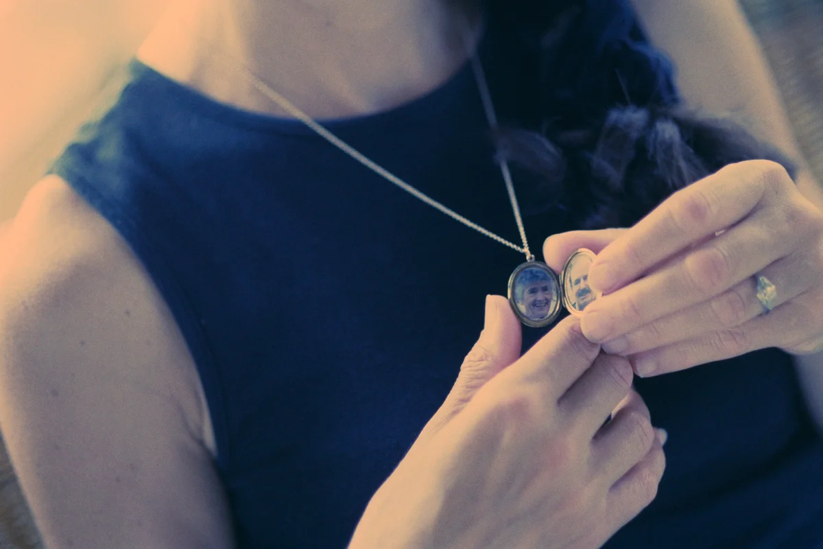 Woman holding Locket with Parents' Photos