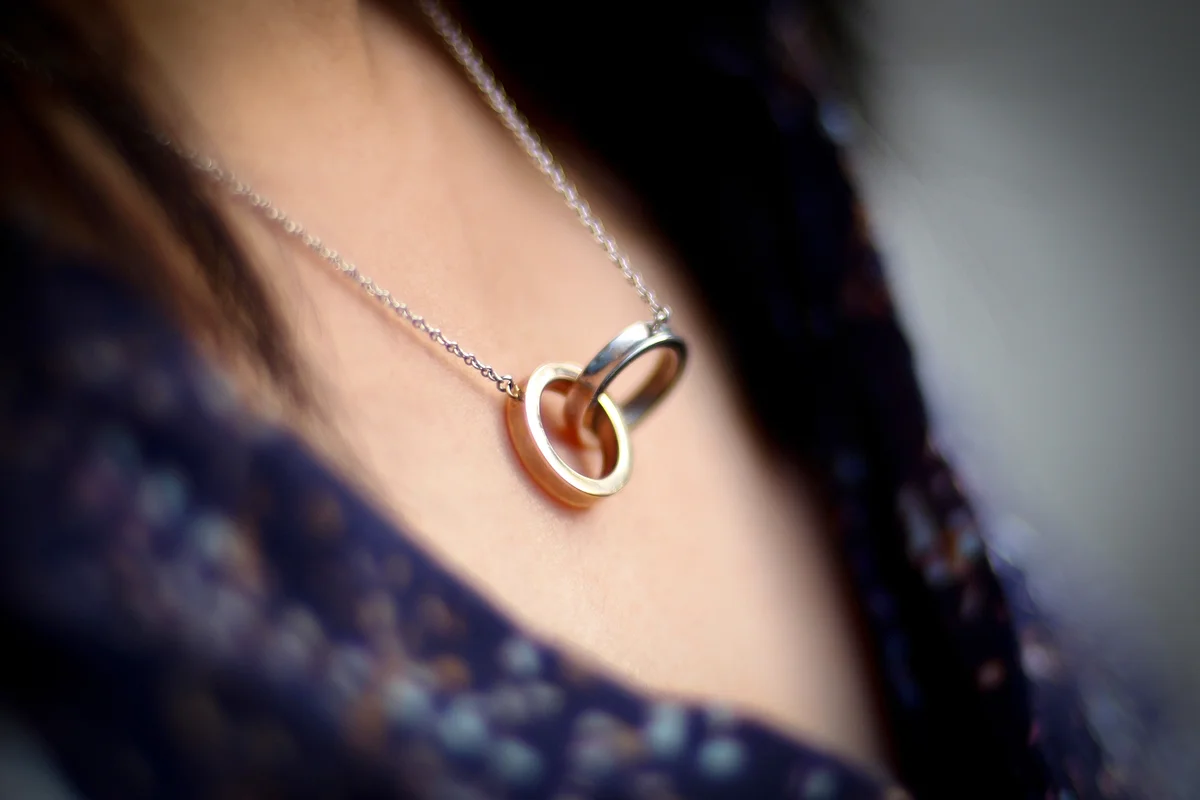 Woman wearing a necklace with two joined rings