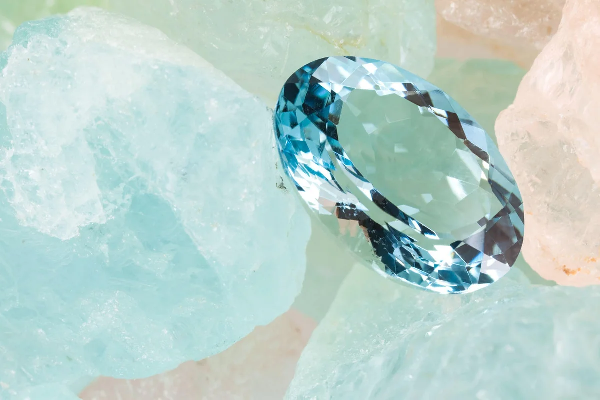 Polished aquamarine is on rough aquamarine gems