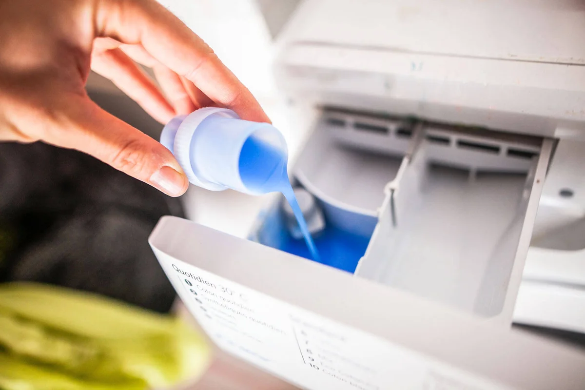 Pouring liquid detergent in the washing machine
