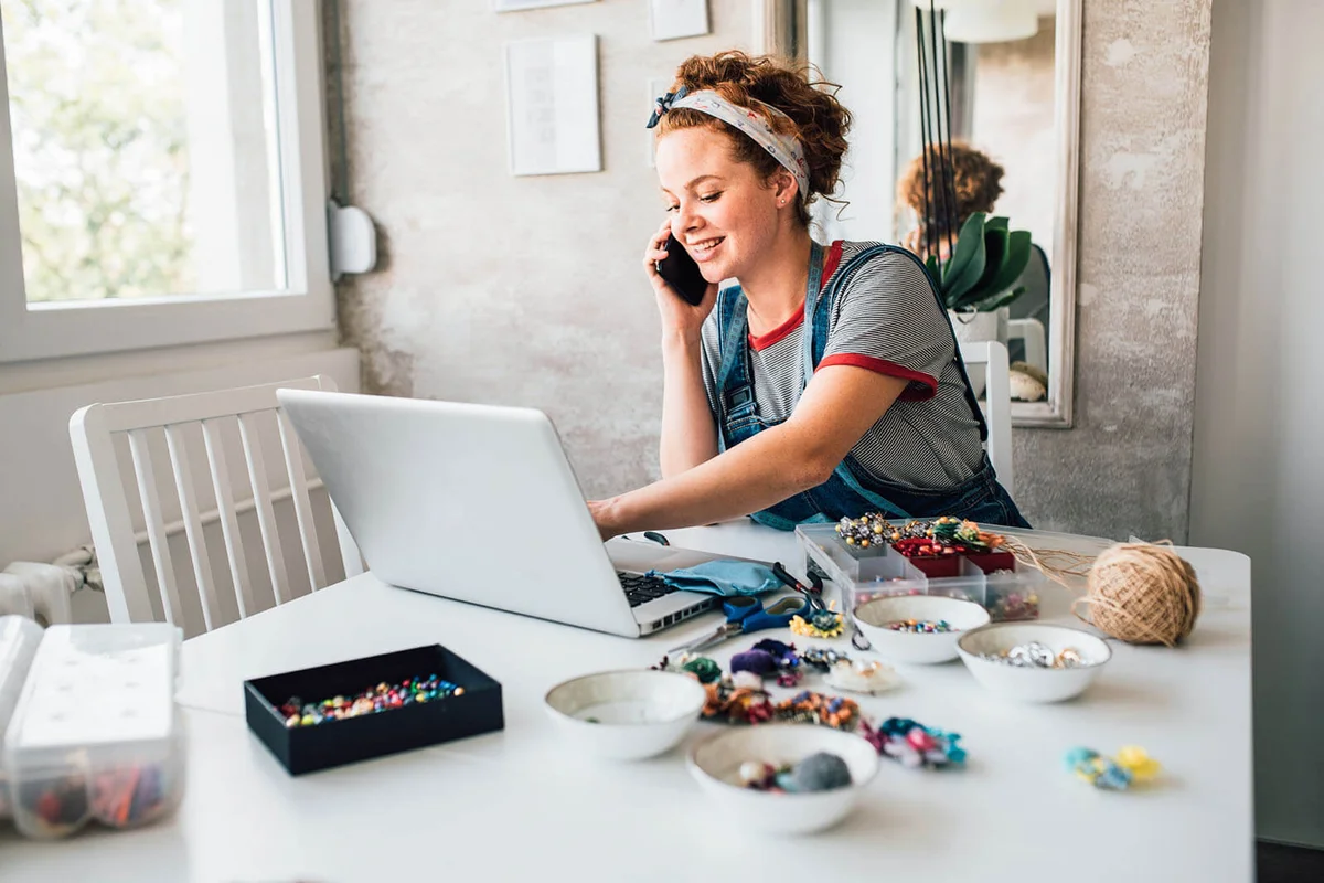 Young woman making jewelry and selling it online