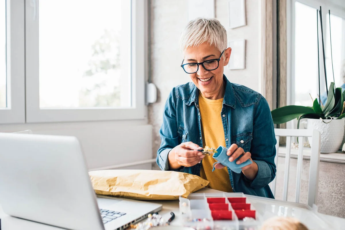 Mature woman making jewelry at home