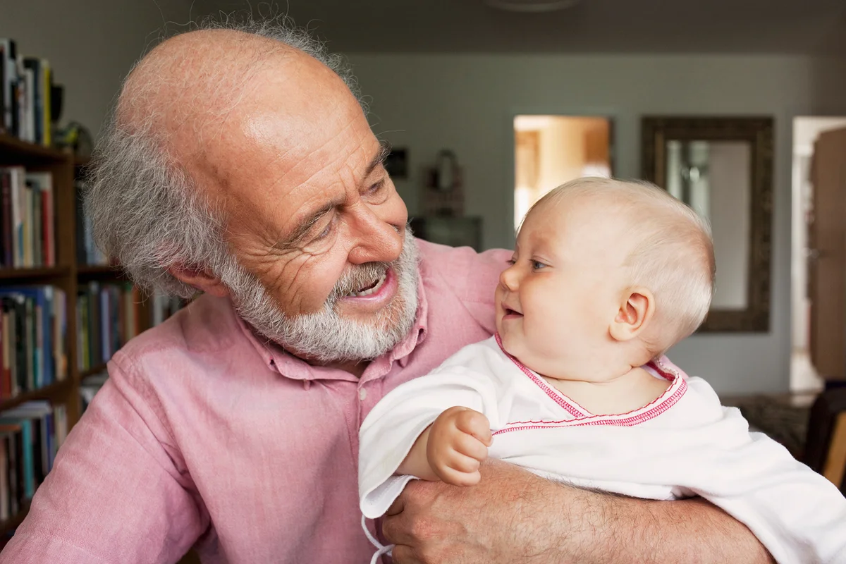 Grandparent and baby smiling at home