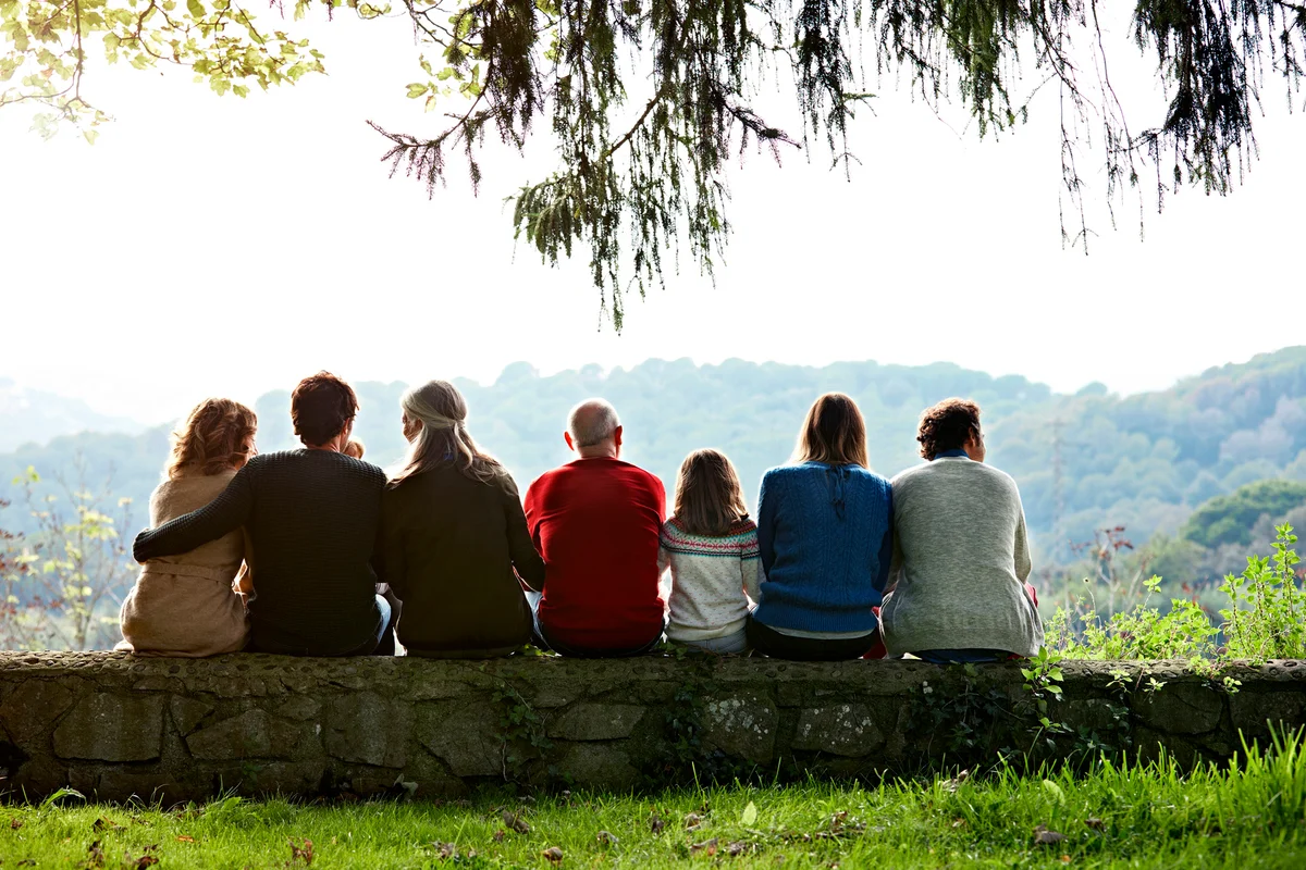 Multi-generation family relaxing on retaining wall