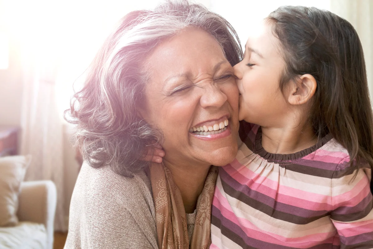 Granddaughter kissing cheek of grandmother