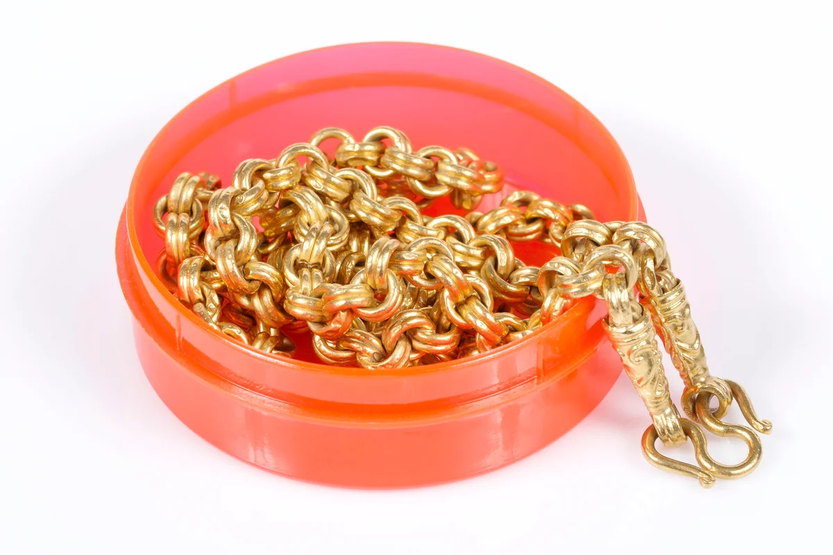 Gold necklace in circle container