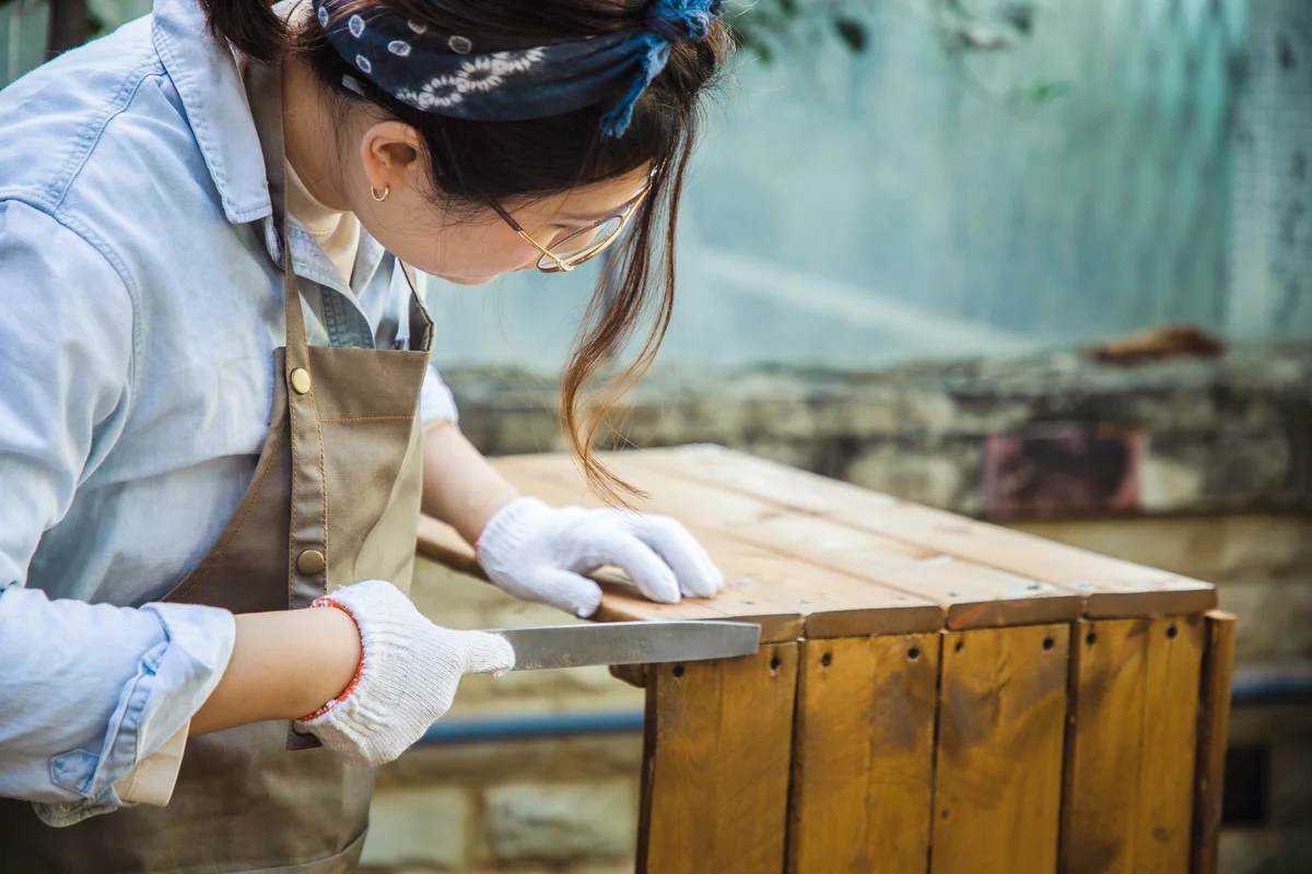 Woman shaping wood with rasp