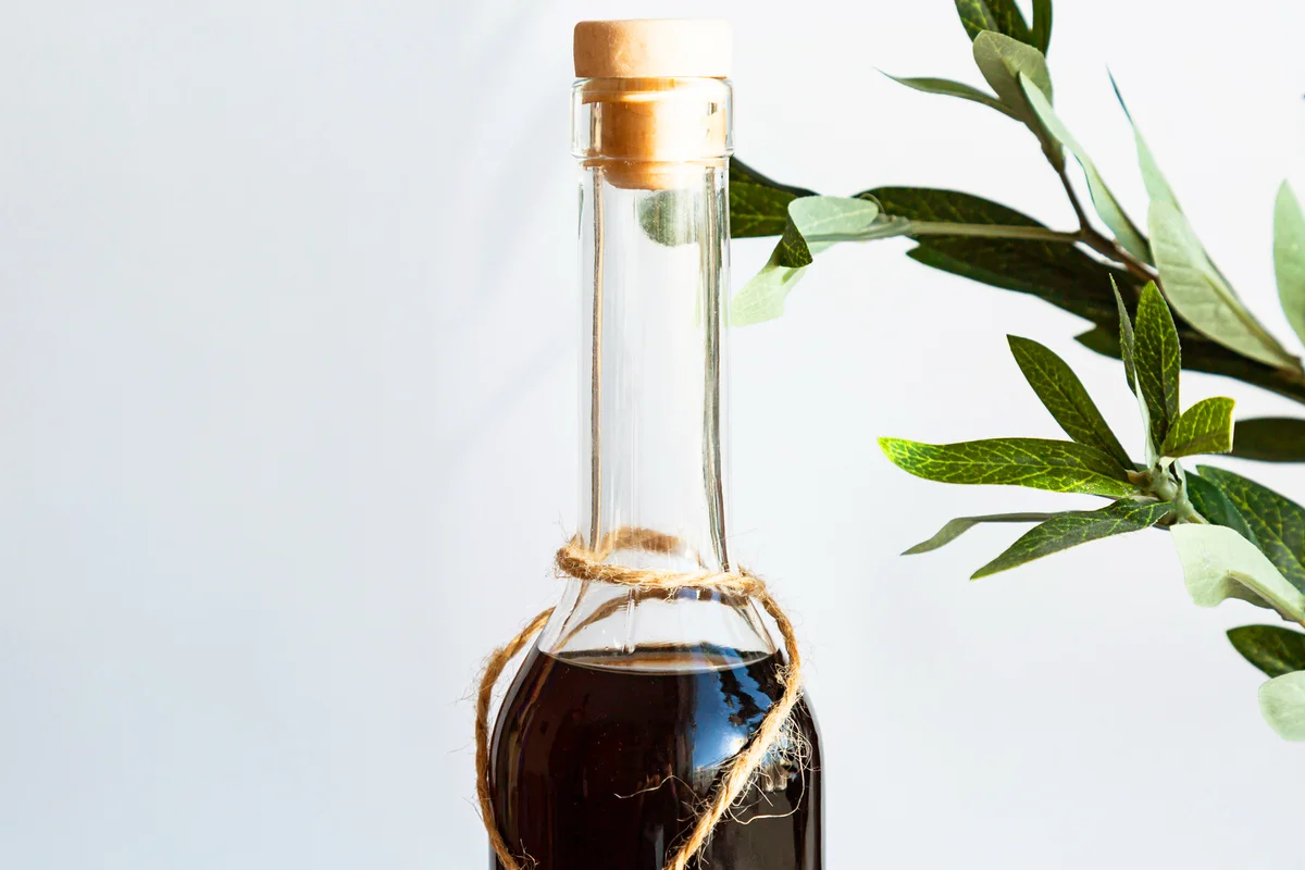 A bottle of rum drink with a green olive branch