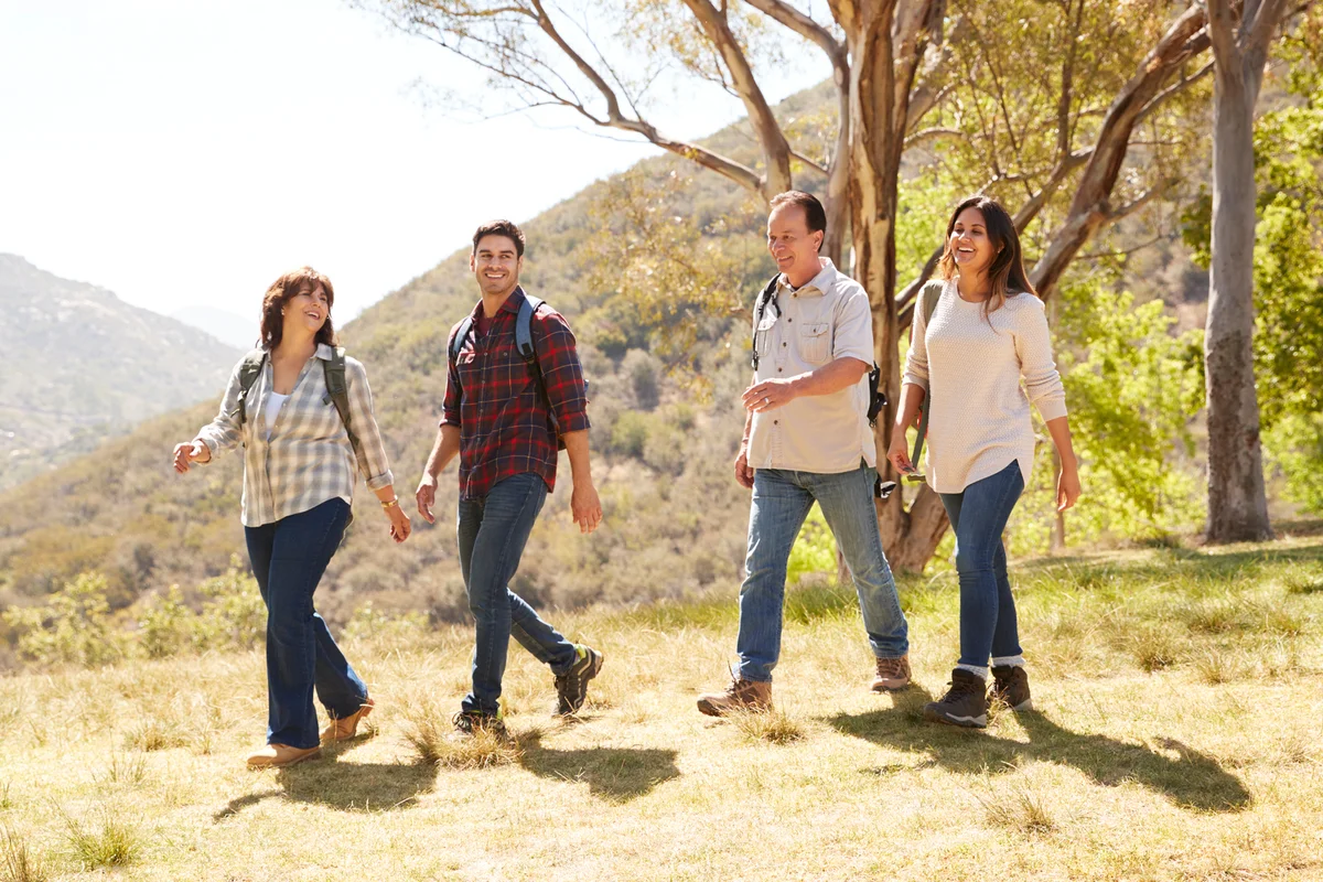 Couple and senior parents smiling during a mountain walk