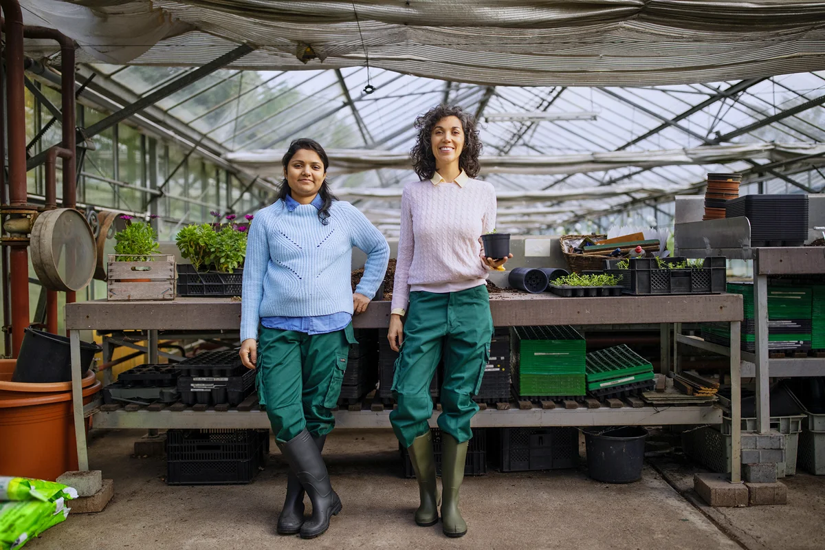 gardeners standing together in greenhouse