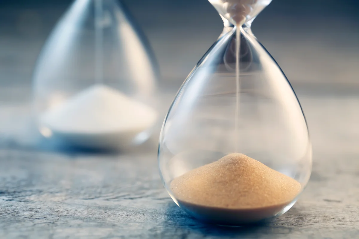 Flowing hourglass on wooden table