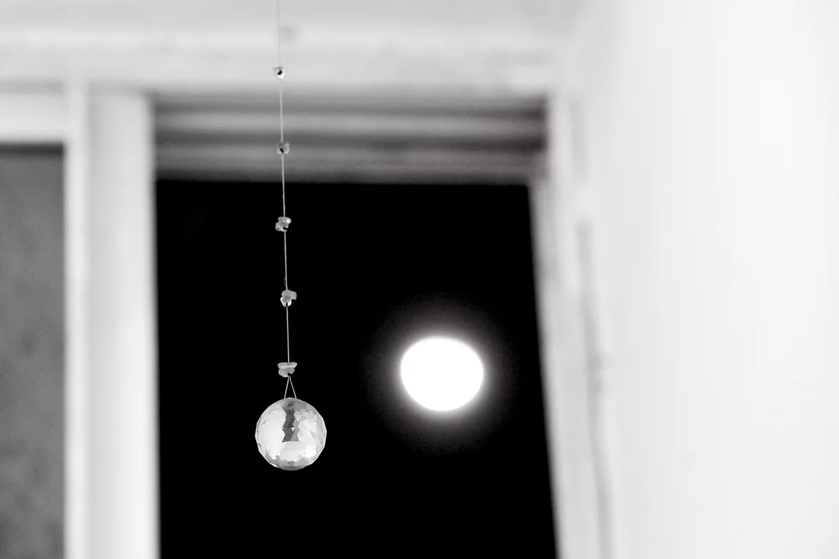 Crystal Ball On Ceiling Against Full Moon Seen Through Window