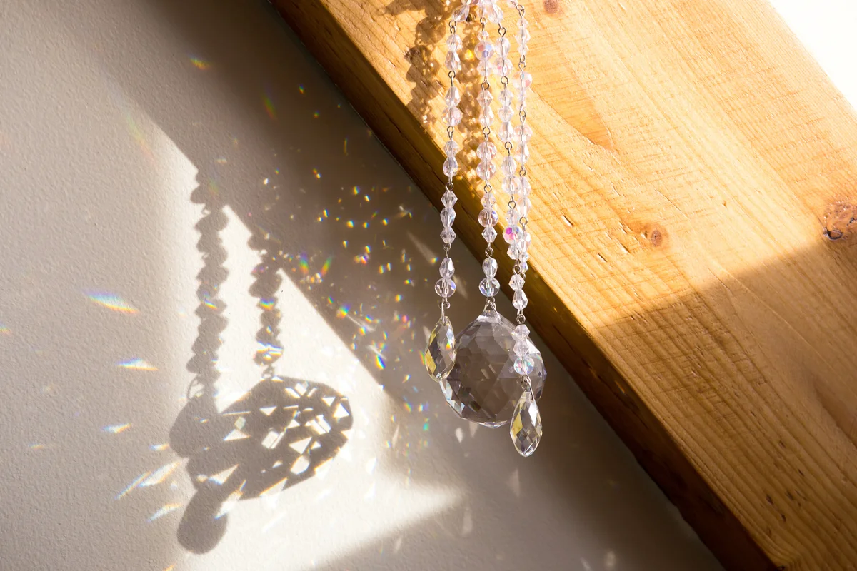Ball and teardrop shape crystal rainbow maker sun catcher hanging in home