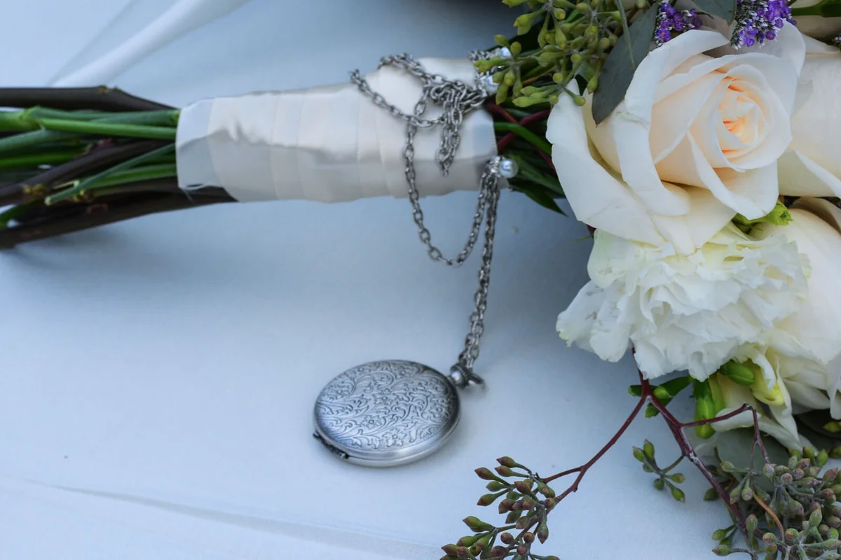 White Roses On Table with silver locket
