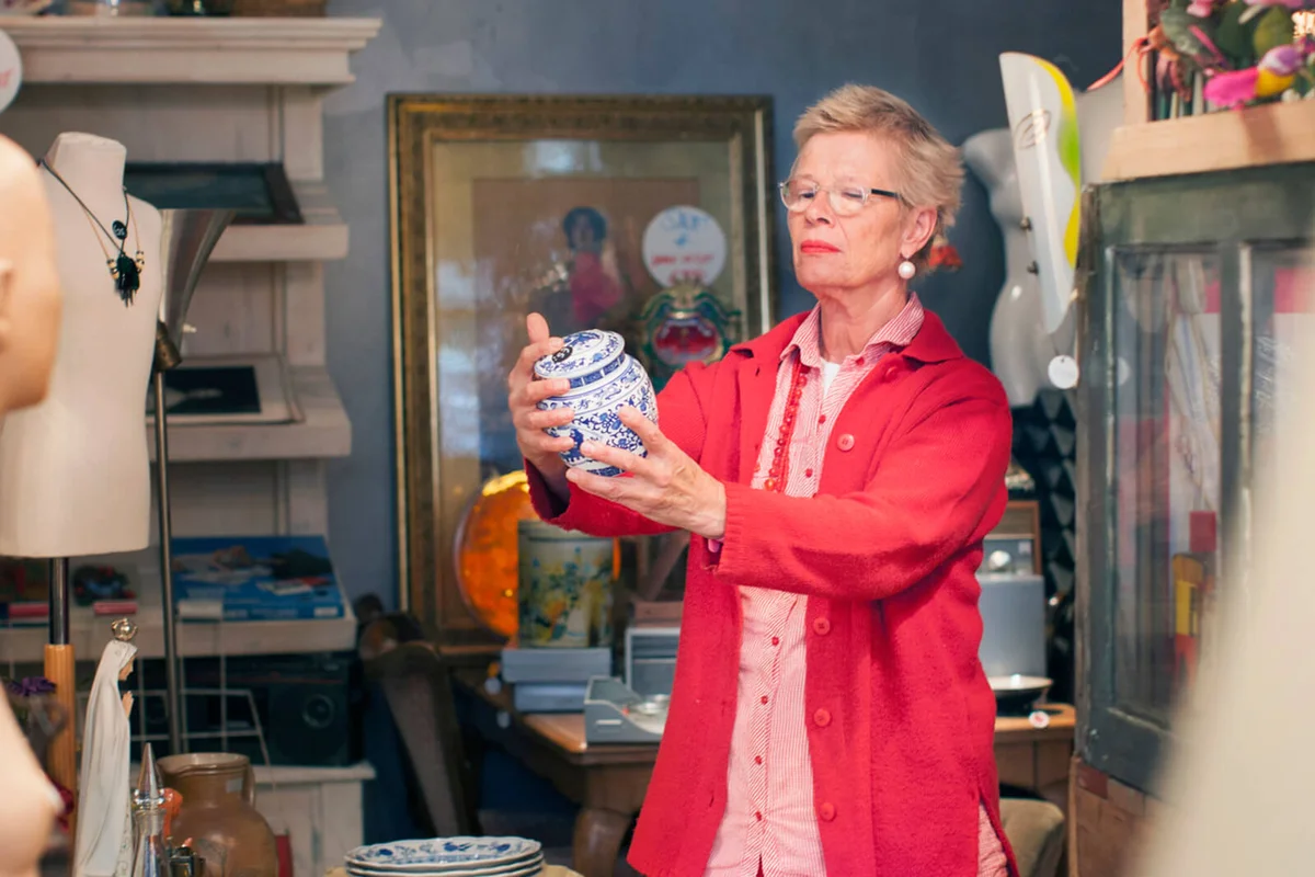 Mature woman examining china pot in vintage shop