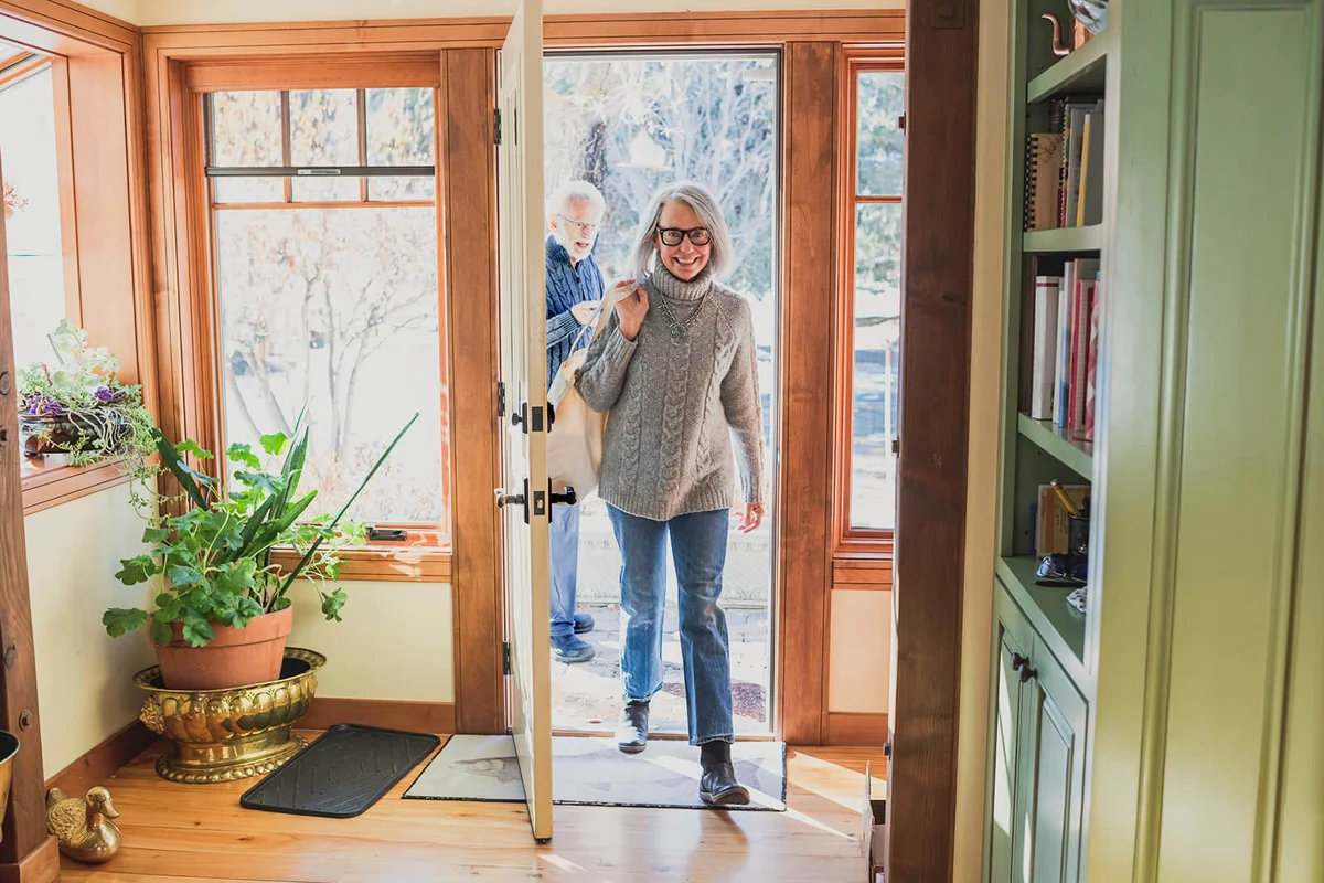Man and woman arriving home with shopping