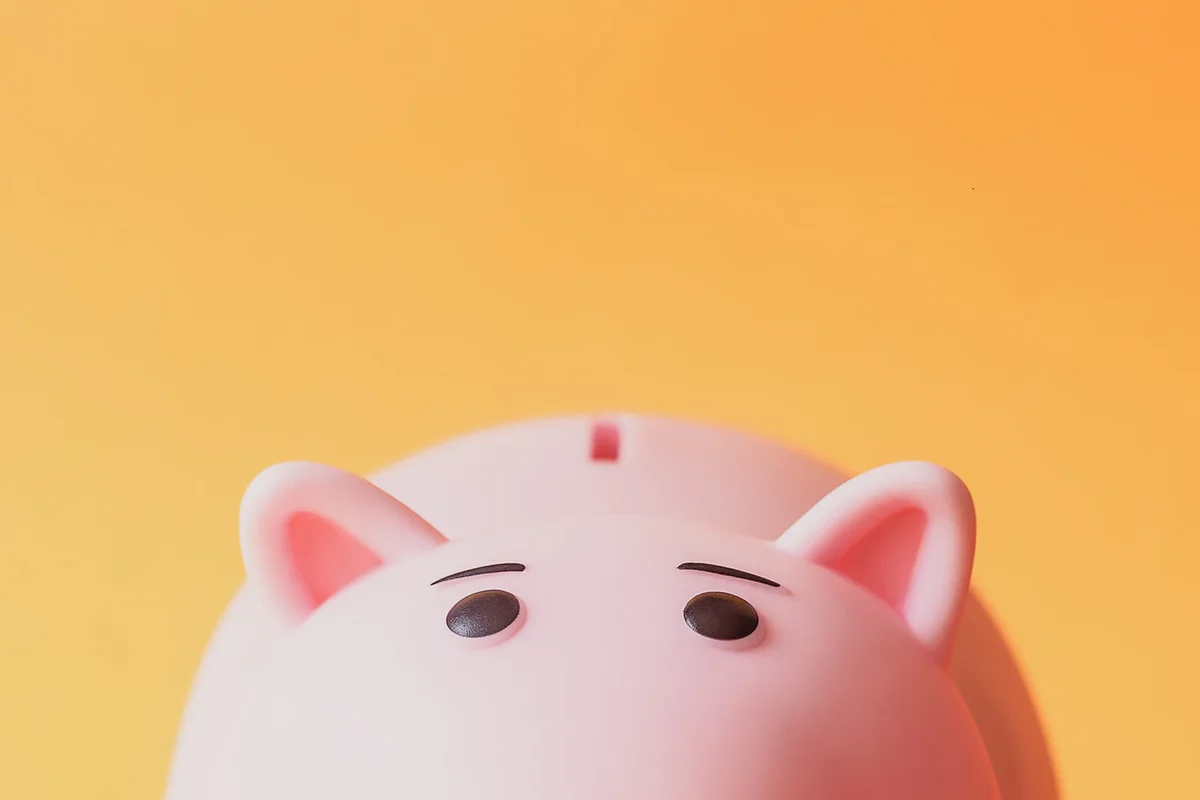 Pink Piggy Bank Against Orange Background
