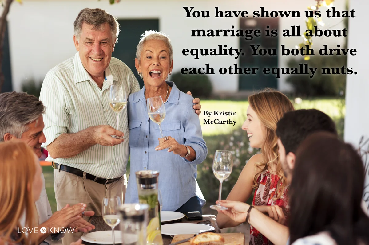 Happy senior couple with family having lunch together outside