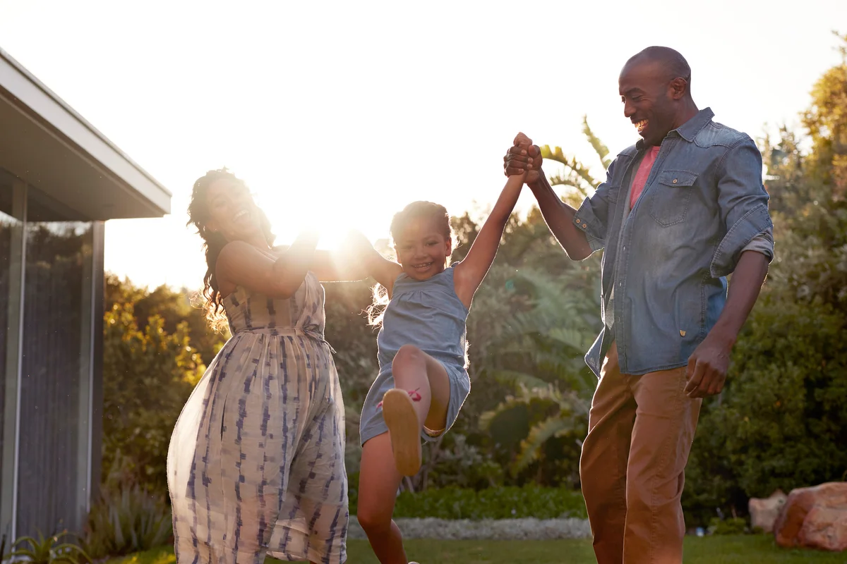 Parents playing with their kid in the garden