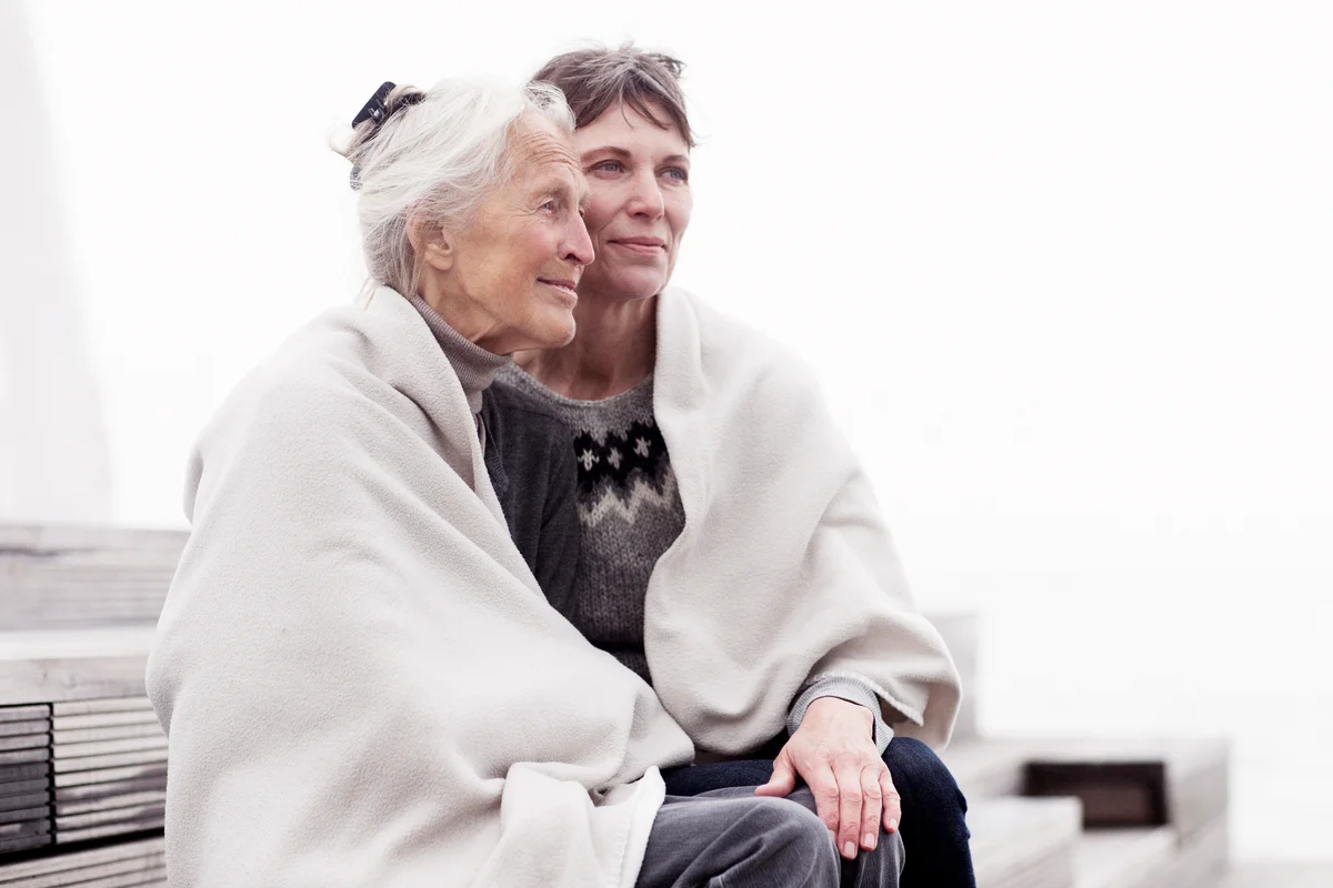 Two generations of women, wrapped in a blanket