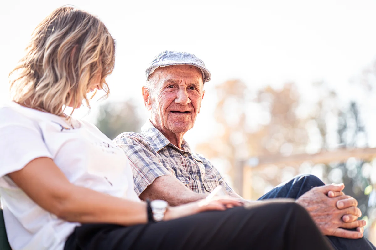 Woman and old man sitting and talking