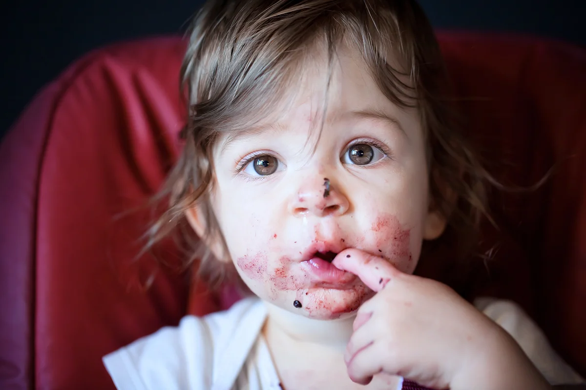 Baby girl eating blueberries