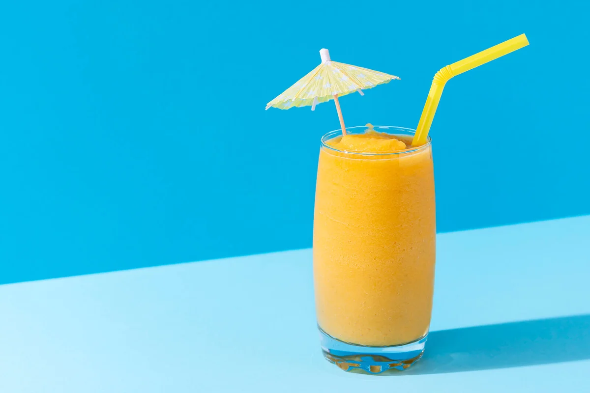 Mango smoothie with a cocktail umbrella