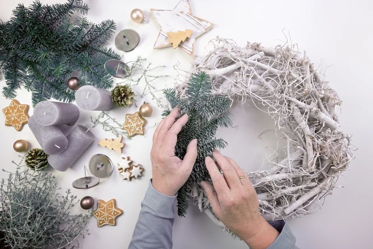 Older woman decorating a christmas wreath