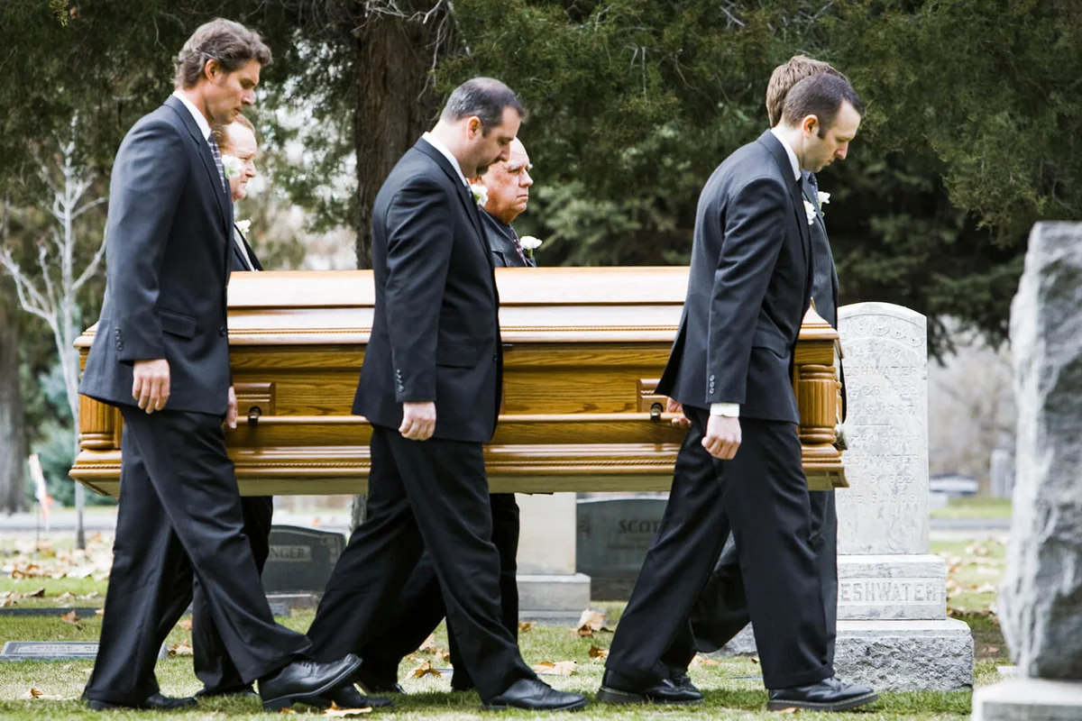 people at a funeral in a cemetery
