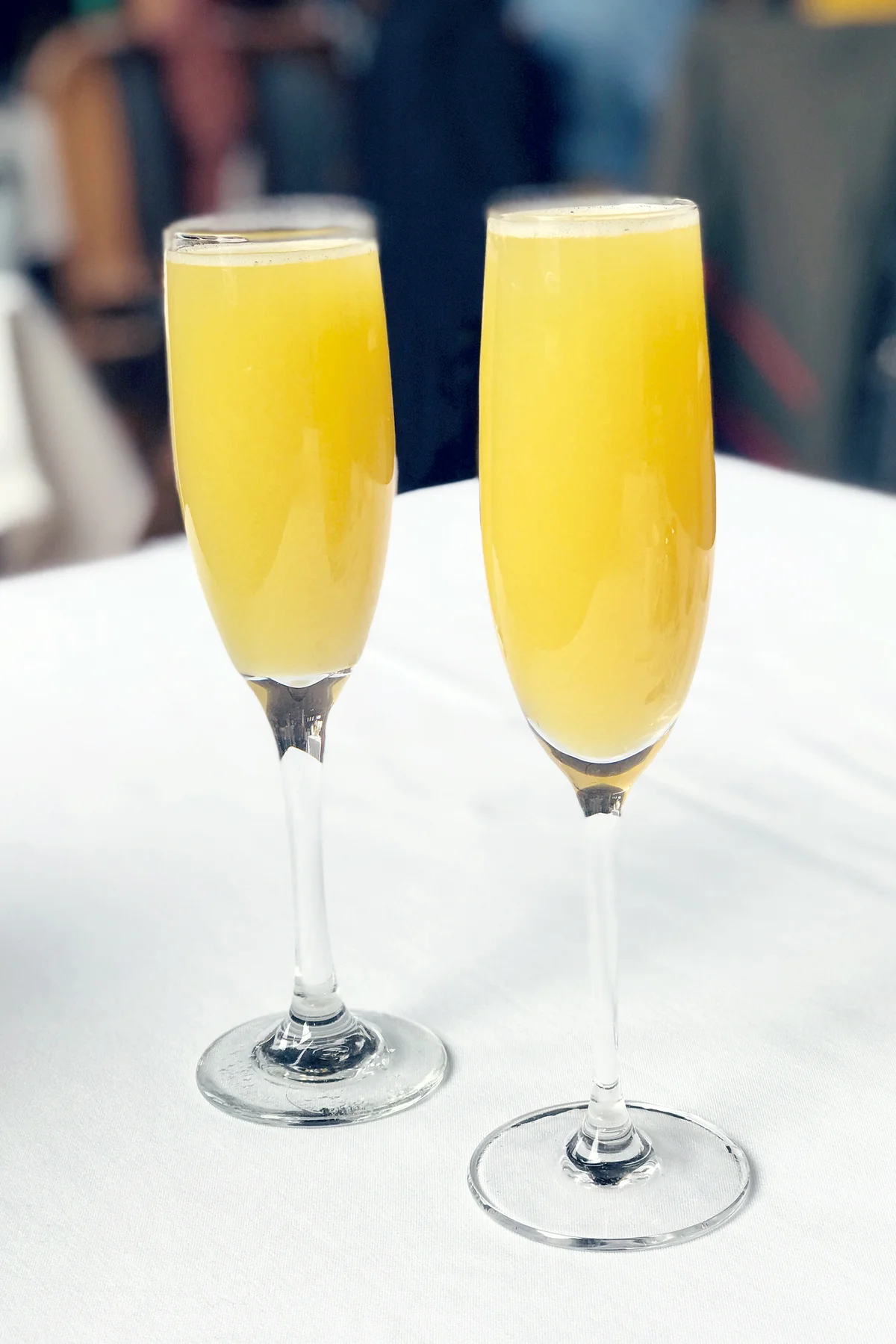 Two mango mimosas in champagne glasses