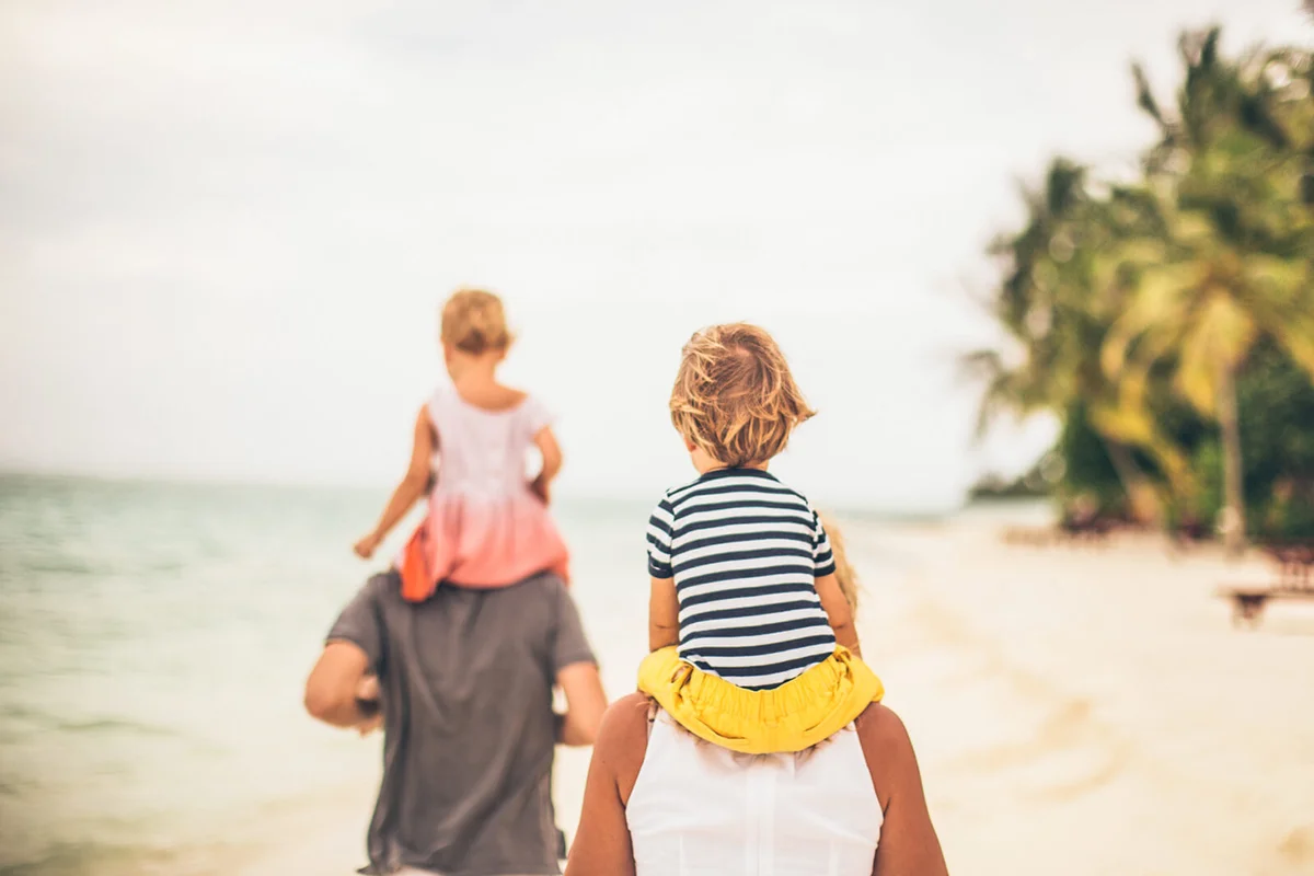 young family walking by the sea