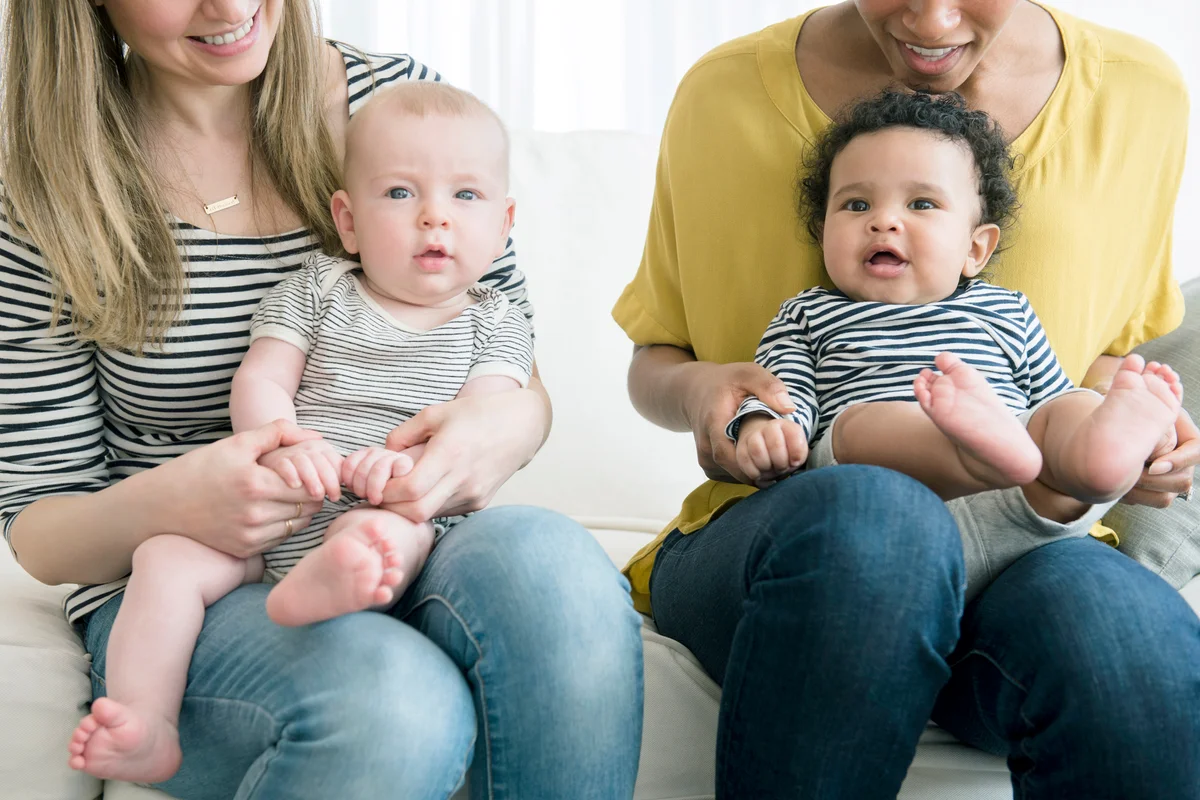 Mothers holding baby sons in laps