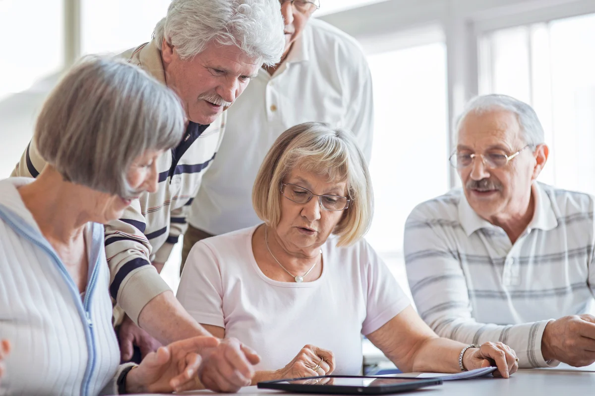 Group of seniors looking at digital tablet in the classroom