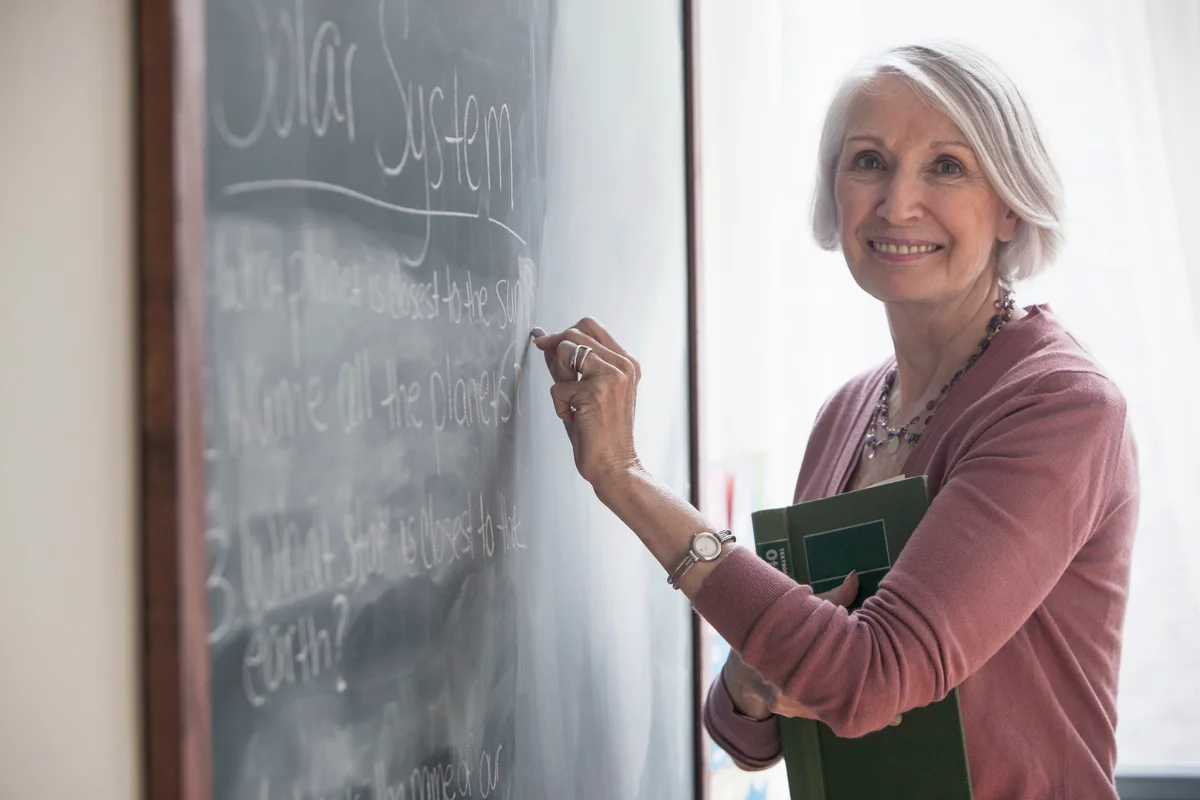 Senior woman writing on chalkboard