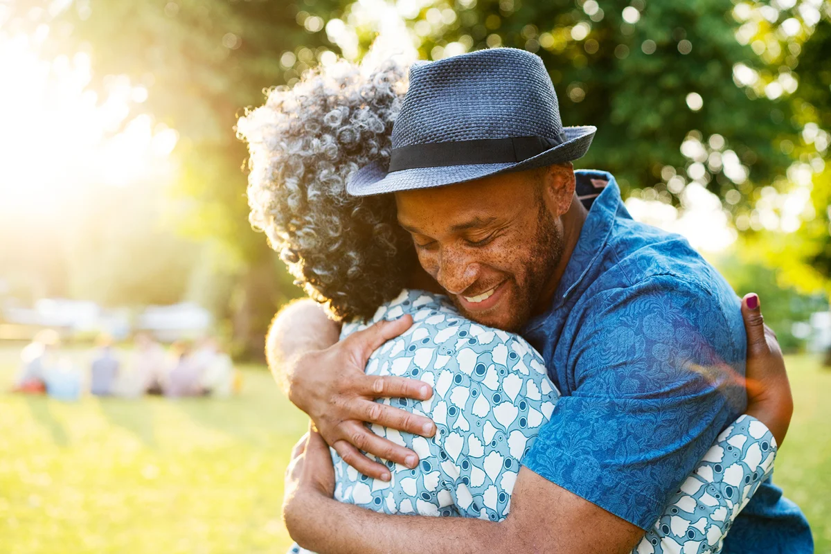 Son and mother hugging in park