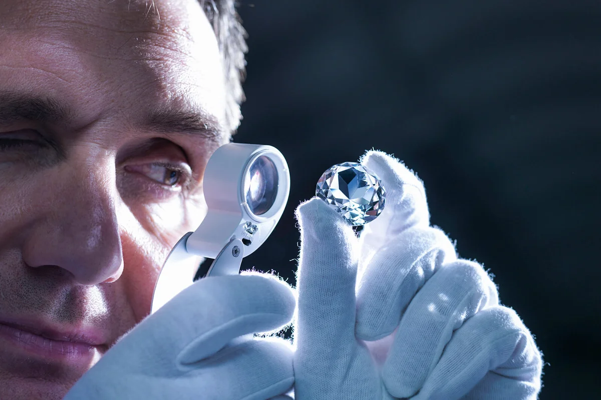 Jeweller inspecting replica diamonds with loupe