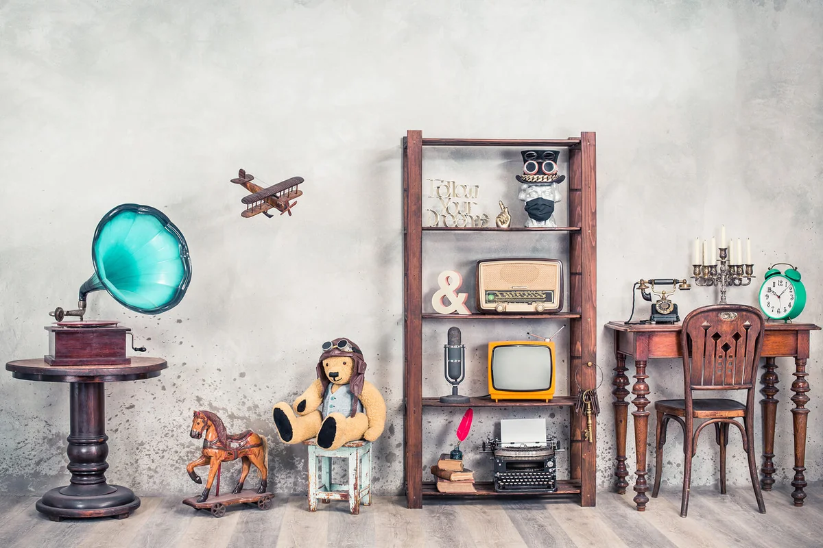 Antiques still life with old gramophone, Teddy bear, rocking horse and collection of outdated media, news makers and writers devices