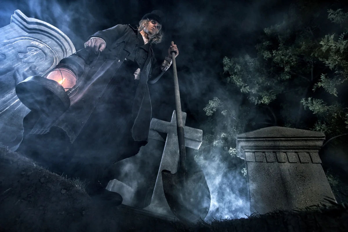 Grave digger standing over grave